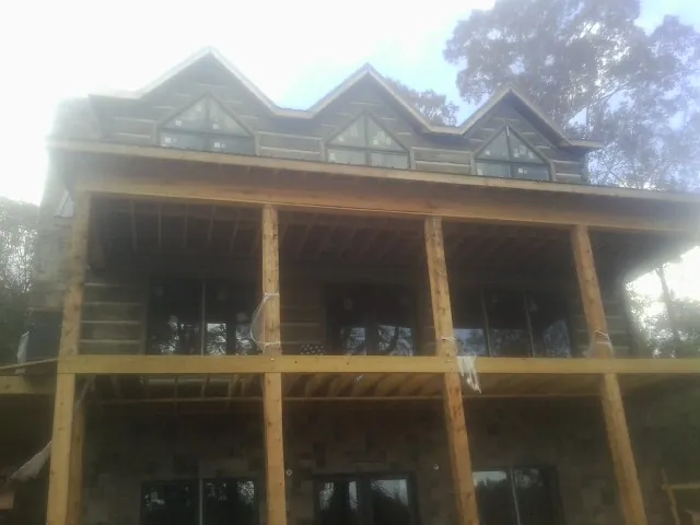 Dormers and porch framing on a large log home under construction — Roof Coating work by our crew in Buckhannon