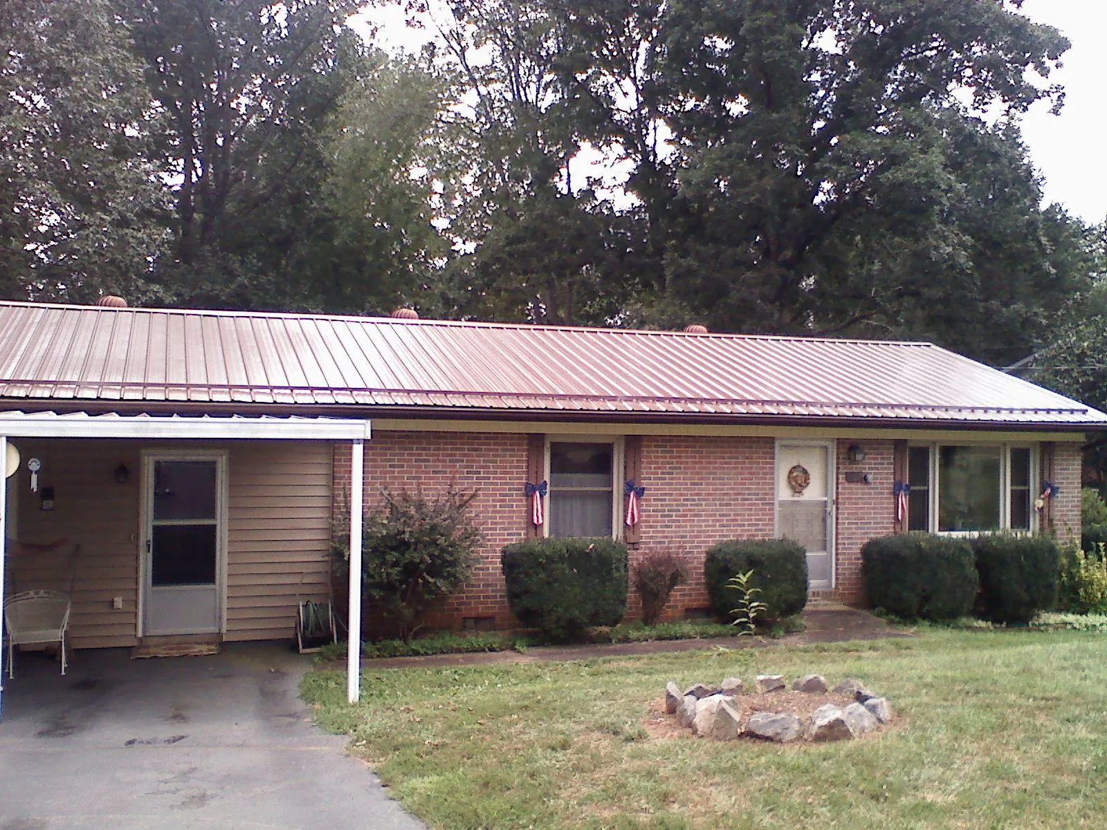 Bronze metal roof and carport on a brick ranch home — Roof Repair work by our crew in Buckhannon